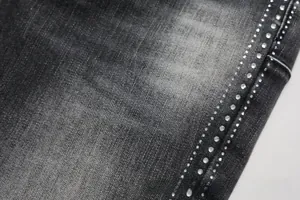 Macro detail of charcoal grey denim featuring double row white rhinestone side seam decor