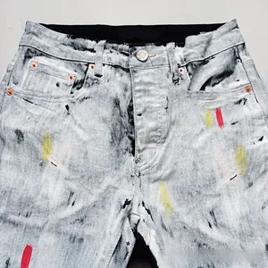 Detail of acid wash texture and colorful paint splatter on slim fit denim jeans