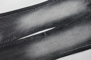 Close-up of silver rhinestones on slim fit washed denim jeans for men in dark grey