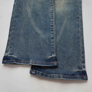 Detalle del dobladillo de los vaqueros acampanados azules con lavado vintage y costuras