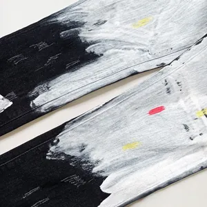 Detail of black and white spray paint graffiti texture on heavy denim street jeans