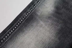 Close-up of distressed dark grey denim fabric with sparkling rhinestone embellishments