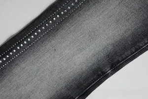 Detail of dark gray flare jeans featuring four rows of polished white rhinestones