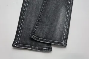 Detail of flared jeans cuffs featuring double rows of rhinestones and raw fringe edges