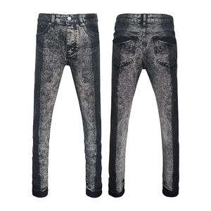 Close-up of black grey acid wash denim texture on slim fit men's street style jeans