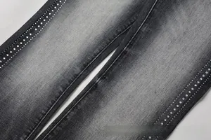Detailed macro view of washed denim fabric featuring vertical rows of sparkling rhinestones