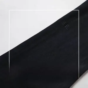 Nahaufnahme von schwarzem Denim mit Stickerei, das Dehnbarkeit und Textur zeigt