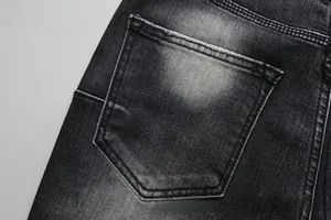 Detail view of back pocket on men's black flared denim jeans with vintage washed effect