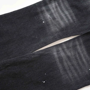 Primer plano de los vaqueros gris oscuro con manchas de pintura blanca y efecto lavado