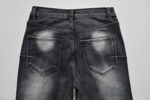 Detail of dark gray washed denim back pockets and belt loops on flare jeans