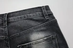 Detail of dark grey washed denim jeans showing back pocket texture and reinforced stitching