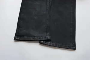 Detailaufnahme des schwarzen Slim-Fit Denim-Saums mit präzisen Doppelnähten
