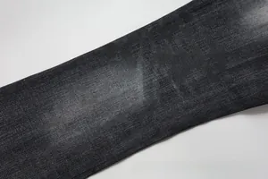 Close-up of dark grey flared denim jeans with vintage washed texture and twill fabric