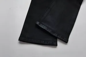 Detailaufnahme des Beinsaums einer schwarzen Denim-Jeans mit hochwertiger Naht