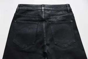 Detail einer schwarzen Schlagjeans mit gesticktem Kreuz auf der hinteren Tasche