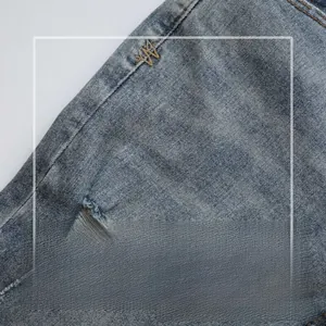 Close-up of blue distressed denim fabric with high elasticity and clear texture
