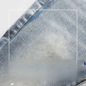 Macro detail of stretch light blue denim fabric showing clear twill texture and soft wash