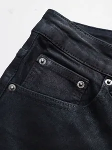 Schmal geschnittene schwarze Schlagjeans für Herren aus Denim mit Metallnieten