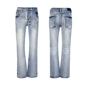 Détail d'un jean évasé bleu clair délavé avec texture vintage et broderies croisées au dos