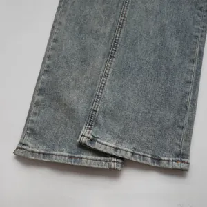 Detail shot of light blue washed denim jeans cuff featuring classic orange contrast stitching