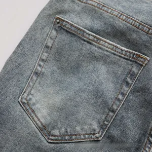 Detail view of denim jeans back pocket with vintage wash and reinforced metal rivets