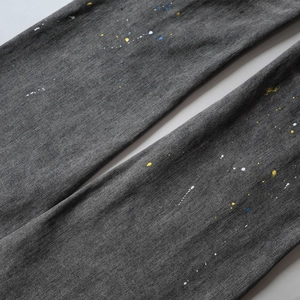 Detailed macro view of gray denim fabric with artistic colorful paint splatter spots