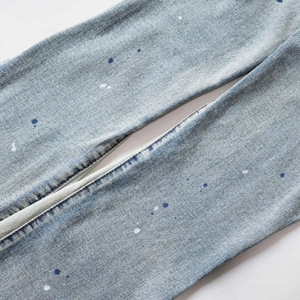 Detail of light blue denim fabric with unique blue and white paint splatter effect