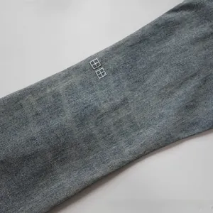 Detail of light blue washed denim fabric with square grid embroidery texture