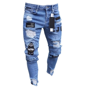 Close-up of hip hop jeans featuring Eat Chicken embroidery and distressed ripped details