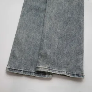 Detail view of denim hem with vintage light blue wash and durable double-stitched seams