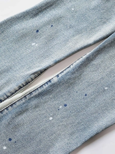 Light blue stacked flare jeans with vintage wash and artistic paint splatter detail