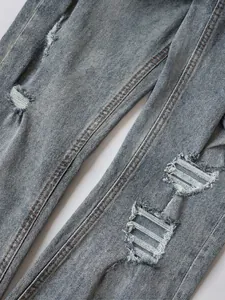 Men's light blue distressed jeans with flare fit and washed denim ripped details