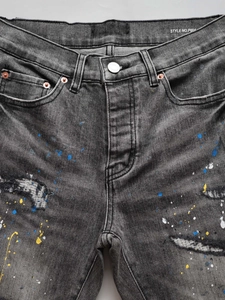 Men's grey ripped flared jeans with colorful paint splatter and frayed denim details