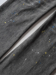 Men's dark grey ripped flared jeans with artistic colorful paint splatter street style