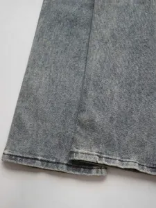 Close-up of light blue washed denim flared jeans with detailed stitching and raw hem finish