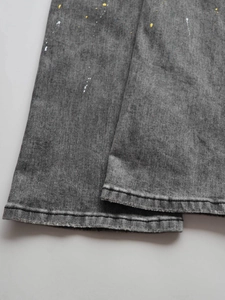 Men's washed grey distressed jeans with paint splatter and fringe detail on the leg