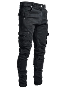 Détail du jean cargo noir ajusté avec poches latérales et un design de jambe empilé tendance