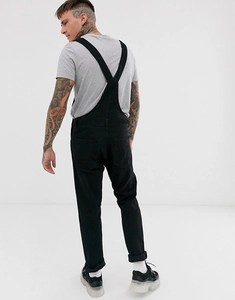 Rear view of men's black denim overalls featuring cross straps and symmetric back pockets