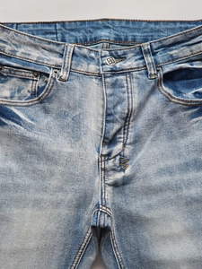 Jean bootcut homme bleu clair délavé vintage avec braguette à boutons et détails usés