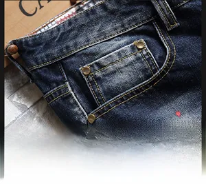 Close-up of distressed blue denim shorts with paint splatters and reinforced pockets
