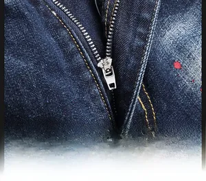 Detail of durable silver metal zipper on deep blue denim shorts with red ink spray design