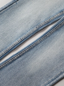 Gros plan d'un pantalon en jean bleu clair délavé vintage avec des surpiqûres détaillées
