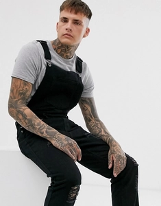 Men's black denim dungarees with ripped knee design and front pocket in studio shot