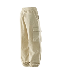 Detailed side view of beige cargo pants showing large utility pockets and elastic cuff