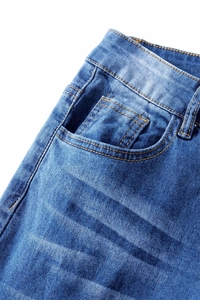 Detail view of dark blue stretch denim jeans showing waist, pockets and orange stitching