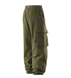 Detail view of olive green cargo pants featuring large side pockets and elastic cuffs