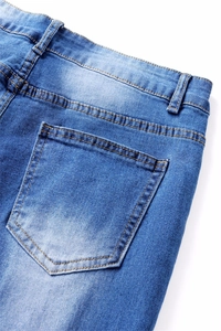 Close-up of blue flare jeans showing back pocket stitching and washed denim texture
