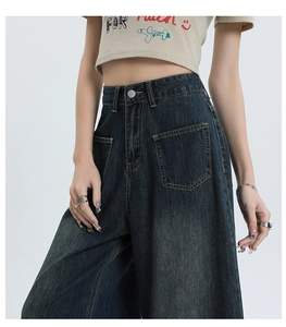 Detailweergave van high waist wide leg blauwe jeans met grote zakken en gewassen denim textuur