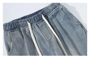 Détail du jean ample montrant la taille élastique et les cordons blancs larges