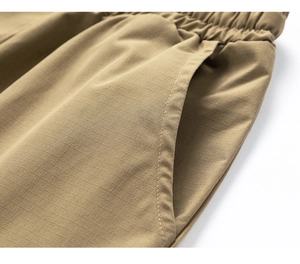 Close-up of khaki casual shorts featuring elastic waistband and ripstop fabric texture